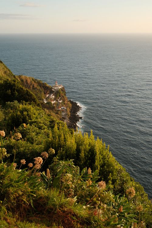 Ein Blick entlang der Klippe auf einen Leuchtturm zur goldenen Stunde.